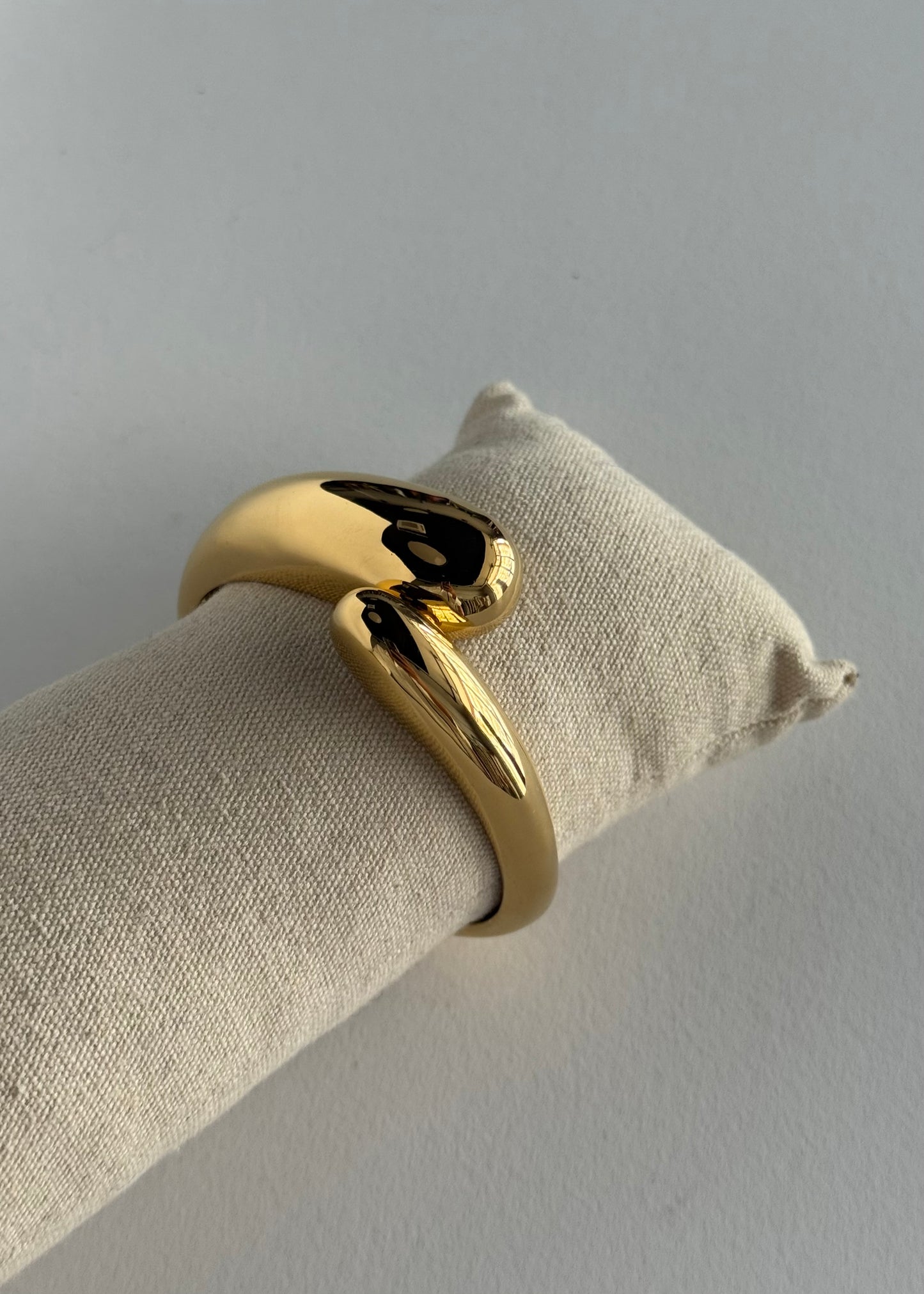 Bracciale rigido dorato con design ondulato