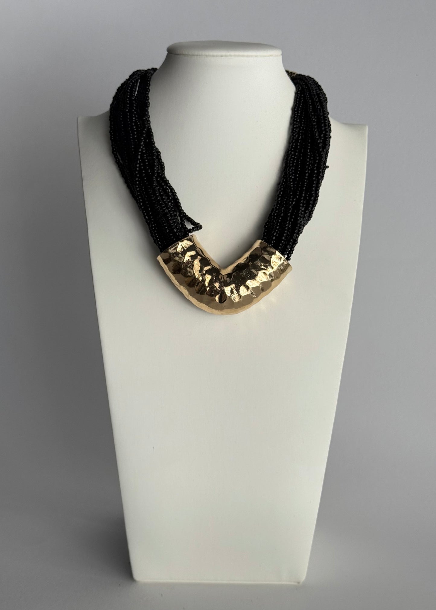 Collana multistrato con perline nere e dettaglio dorato martellato