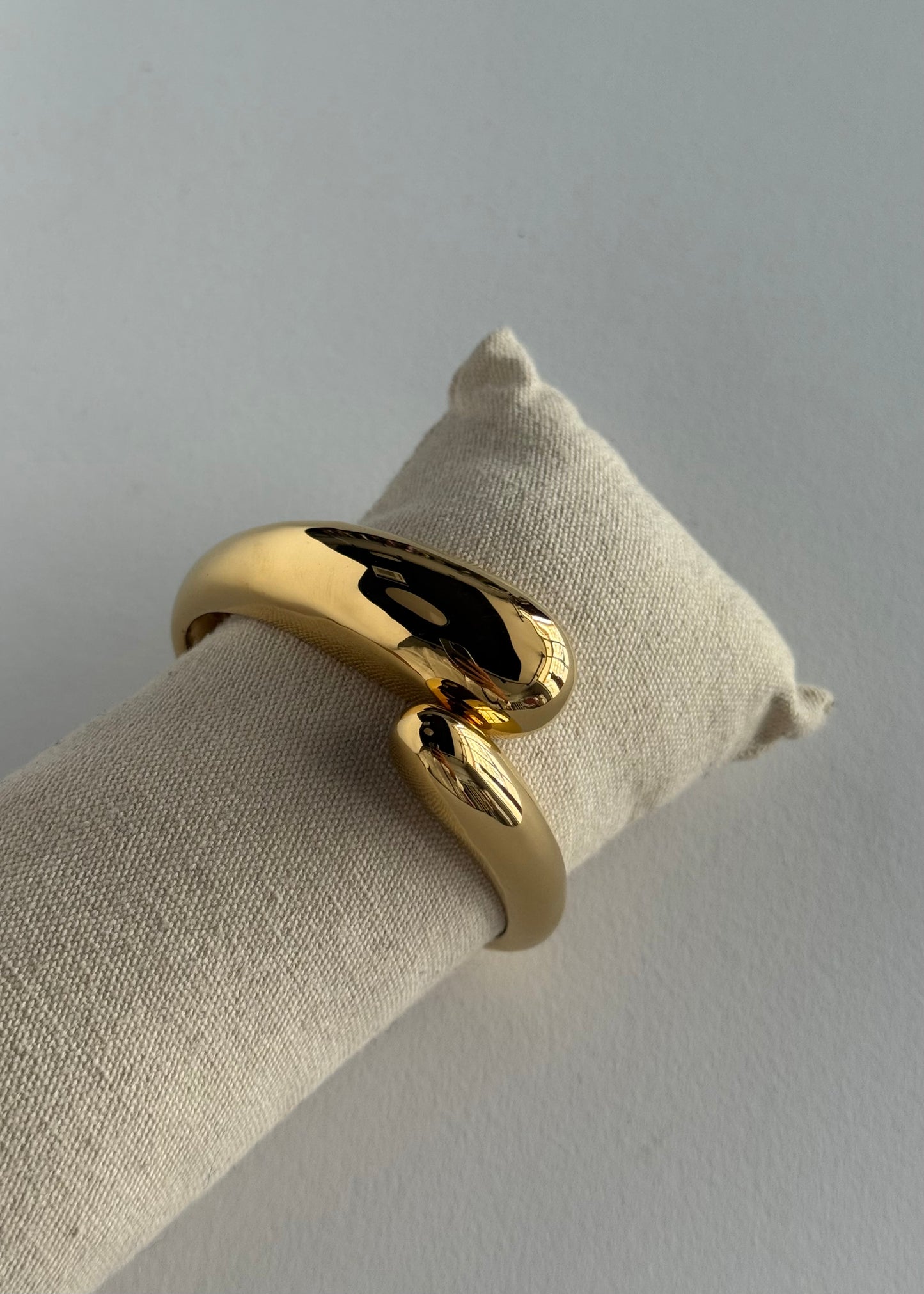 Bracciale rigido dorato con design ondulato