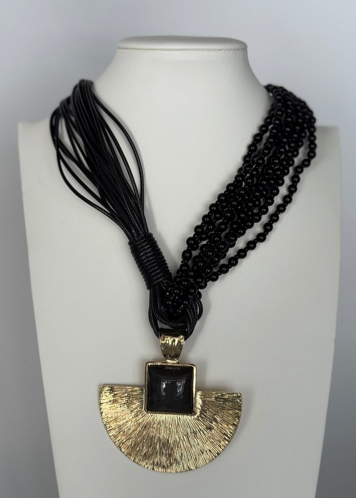 Collana multistrato con maxi pendente dorato e resina nero