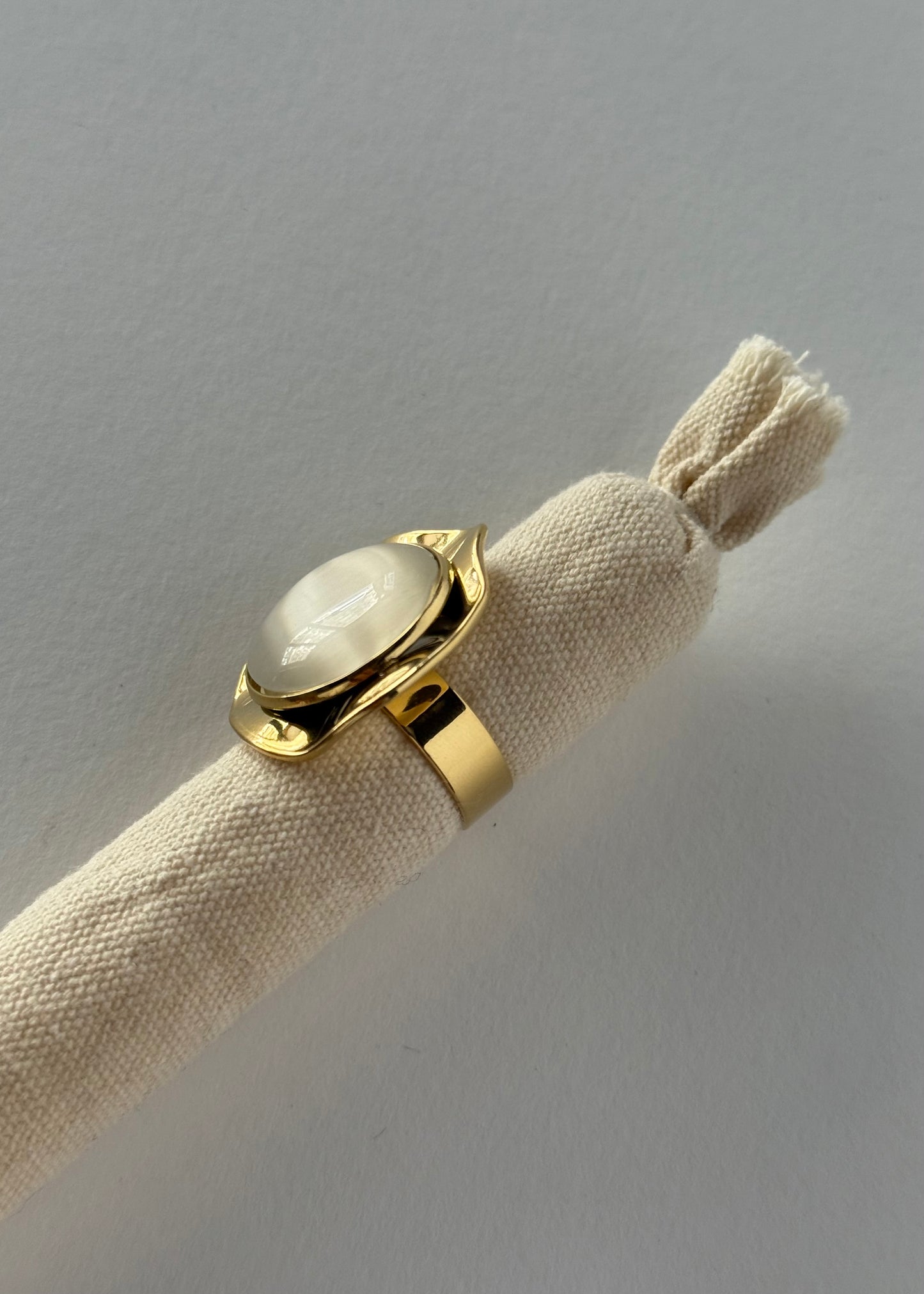 Anello dorato con pietra bianca ovale