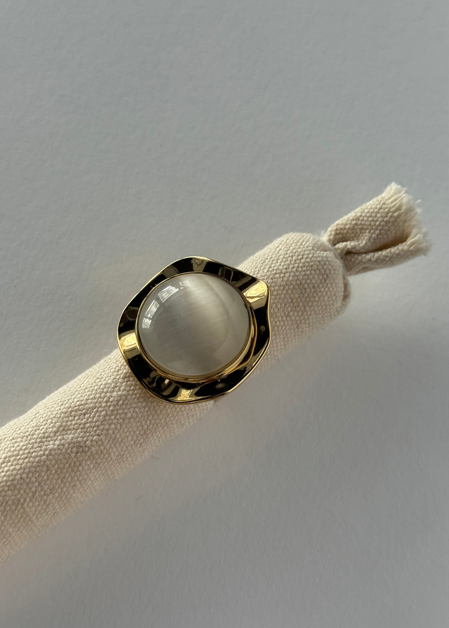 Anello dorato con pietra bianca ovale
