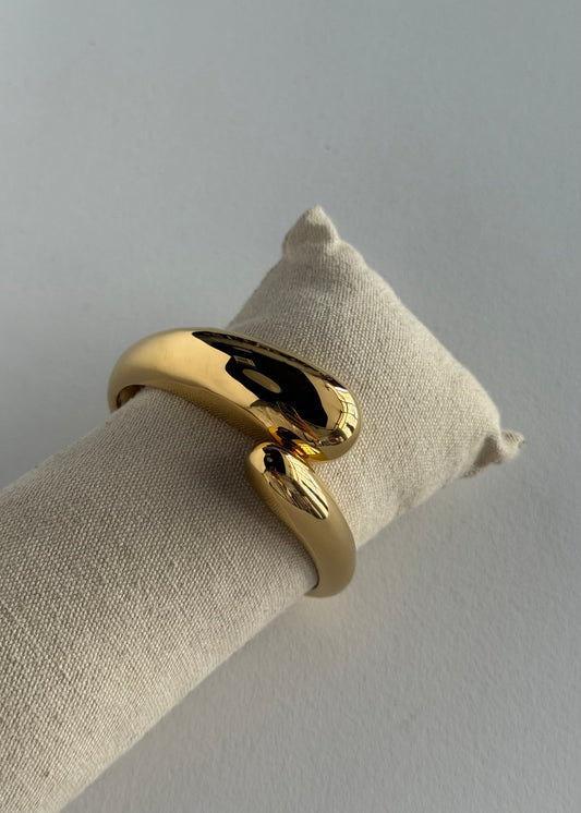 Bracciale rigido dorato con design ondulato